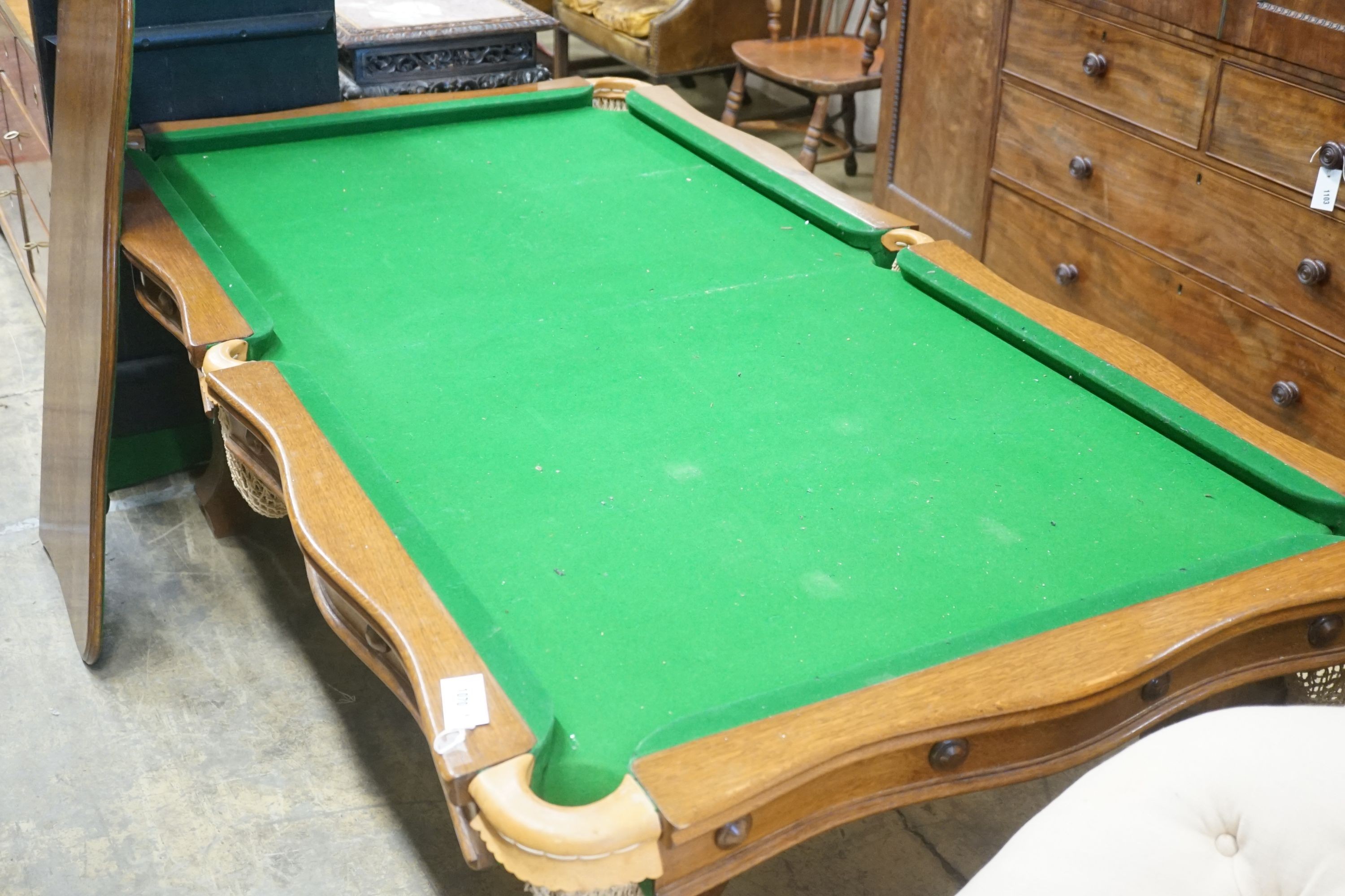 An early 20th century oak snooker / dining table, of rectangular serpentine form, with rise and fall action and full accessories, width 200cm depth 110cm height 74cm